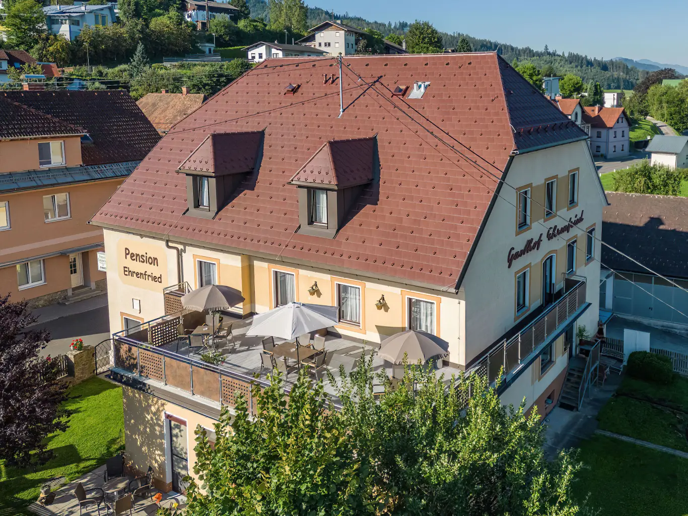 Die Pension Ehrenfried aus der Vogelperspektive mit Sonnenterrasse und Gastgarten